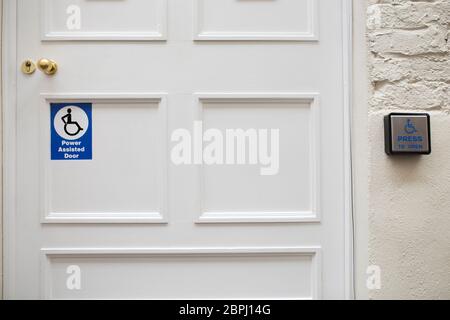 Porte à assistance électrique. Bouton-poussoir pour activation manuelle. Il a été placé à la moitié de la hauteur de la porte Banque D'Images