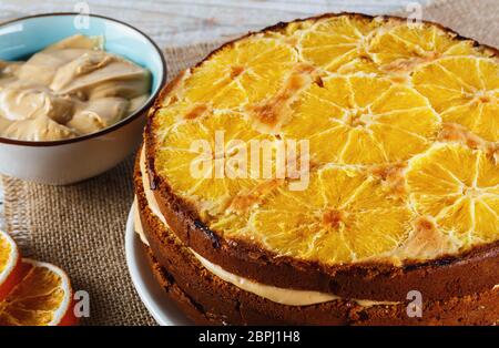 Gros plan du gâteau à la semoule de maïs à l'orange de sang total sur une assiette avec plateau et reste de crème Banque D'Images