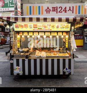 Suwon, Corée du Sud - 15 juin 2017 : une femme vendeur attend les acheteurs dans son kiosque Fast-food dans la rue principale de Suwon. Banque D'Images
