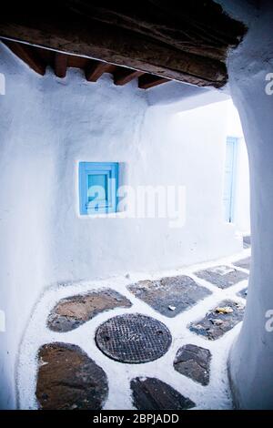 Rue étroite traditionnelle de Mykonos, avec des murs blancs et portes bleu Banque D'Images