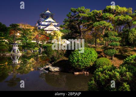 Vue sur le château illuminé d'Osaka depuis le jardin la nuit, Osaka, Japon Banque D'Images