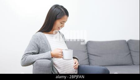 Femme enceinte tenant une tasse de lait Banque D'Images