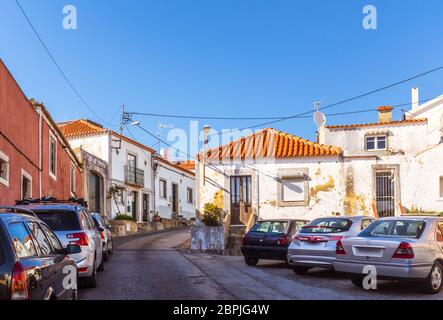 Vue sur la rue des bâtiments blancs et des voitures garées à Almada, Portugal. Banque D'Images