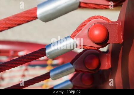 fixation du câble rouge aux œillets de la poutre transversale en métal Banque D'Images