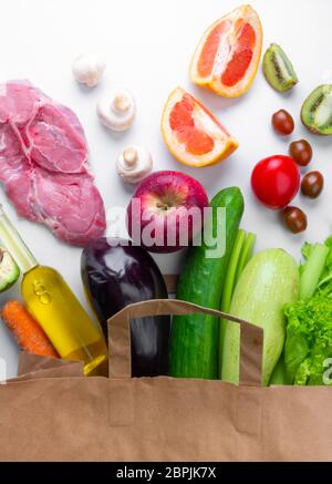 Différents aliments sains d'épicerie dans un sac en papier, gros plan. Aucun gaspillage. Concept de régime équilibré. Vue de dessus. Pose à plat Banque D'Images