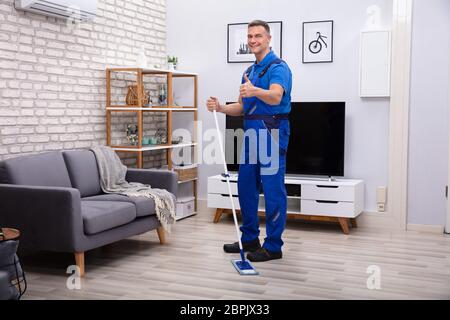 Mâle mature Janitor Cleaning Mop à la maison Banque D'Images