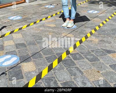 Roermond, pays-Bas - Mai 19. 2020: Vue sur les pieds d'une personne entre ne pas croiser les bandes et les marques bleues pour garder la distance à l'entrée du magasin dans cor Banque D'Images