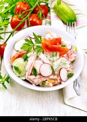 Salade composée de tomates, concombres et radis avec les oignons verts et le persil, aromatisé avec de la mayonnaise et la crème dans une assiette, une serviette sur le backg Banque D'Images