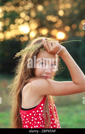 Belle Teen Girl est souriante et aime la nature dans le parc au coucher du soleil d'été Banque D'Images