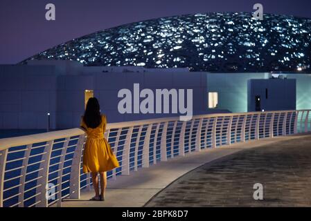 Abu Dhabi, Émirats arabes Unis - 20 novembre 2019 : une femme visite le musée du Louvre à Abu Dhabi extérieur et entrée avec une architecture caractéristique Banque D'Images