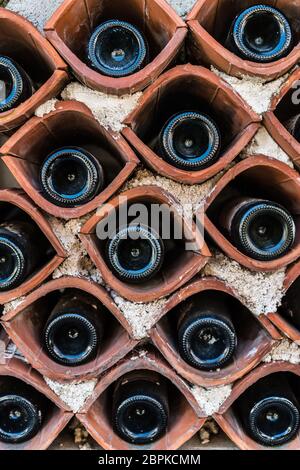 Les bouteilles de vin stocké dans une maison faite en dehors d'un petit stockage primitive maison de village Banque D'Images