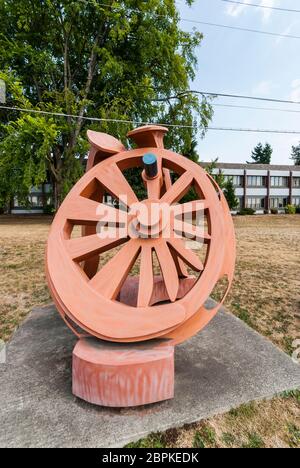 La sculpture de Fritz Church, la "Gateway", est la grande roue orange sur South Tacoma Way à Tacoma, Washington. Il repose sur deux pointes stylisées de chemin de fer. Banque D'Images