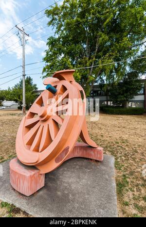 La sculpture de Fritz Church, la "Gateway", est la grande roue orange sur South Tacoma Way à Tacoma, Washington. Il repose sur deux pointes stylisées de chemin de fer. Banque D'Images