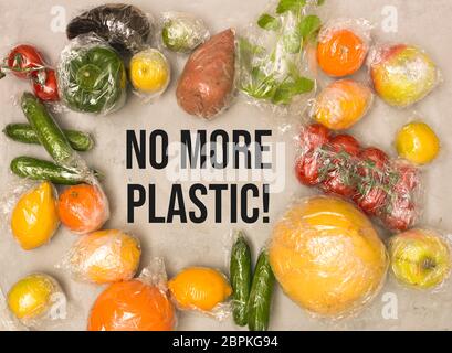 Beaucoup de différents fruits et légumes sont emballés dans un sachet en plastique, paniers sur fond de béton Banque D'Images