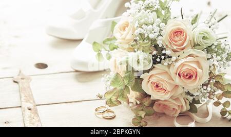 Journée de mariage la composition avec chaussures, fleurs roses rose bouquet de mariée et de mariage vue d'angle élevée sur fond de bois Banque D'Images