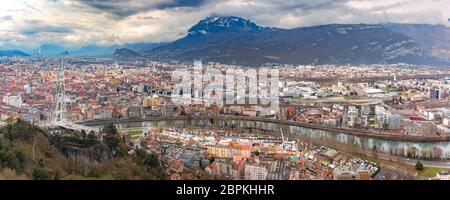 Superbe vue panoramique vue aérienne de les rives de la rivière Isère, pont, les toits et les Alpes françaises sur l'arrière-plan, Grenoble, France Banque D'Images