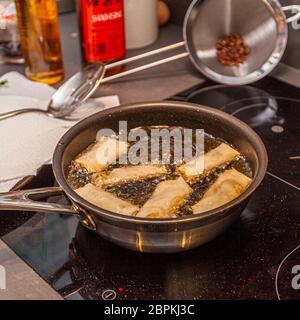 Les rouleaux de printemps sont frits profondément dans un bain d'huile Banque D'Images
