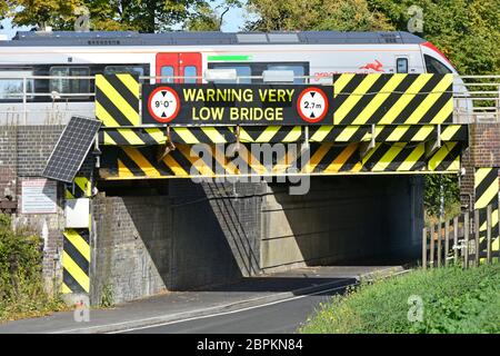 Départ du train de passagers plus Anglia Ely railway station crossing road bridge faible marquage de danger avertissement symboles & Cambridgeshire England UK Banque D'Images