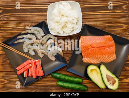 Fruits de mer et ingrédients pour faire des sushis sur fond de bois Banque D'Images