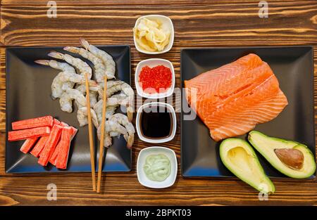 Fruits de mer et ingrédients pour faire des sushis sur fond de bois Banque D'Images