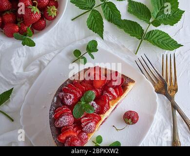 Cheesecake fait de fromage blanc et de fraises fraîches sur une plaque en céramique blanche, vue du dessus Banque D'Images