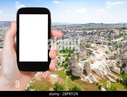 Concept de voyage - photographies de tourisme maisons sculptées et de la ville de Göreme en Cappadoce montagne au printemps en Turquie sur smartphone avec découpe vide Banque D'Images