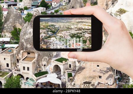 Concept de voyages touristiques - photographies de maisons urbaines dans les grottes de la ville de Göreme en Cappadoce sur smartphone en Turquie au printemps Banque D'Images