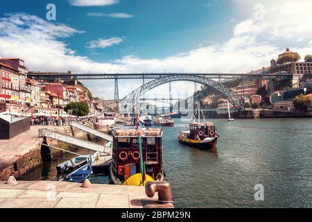 Le pont de fer Ponte Dom Luís I sur le fleuve Douro avec des bateaux à Porto, à gauche les maisons de la vieille ville et à droite le portrin wareho Banque D'Images