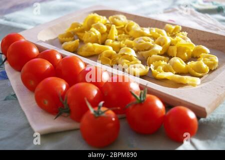 Tortellini farci de matières premières avec tomates Pachino Banque D'Images