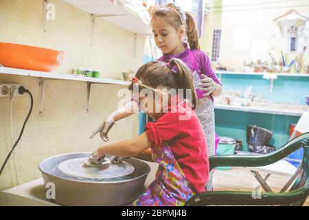 Deux petites filles, l'apprentissage créatif au potter atelier en art studio - Enfant façonner l'argile sur la roue de la poterie Banque D'Images