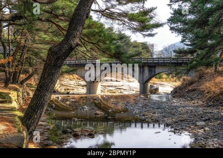 Un petit pont sur l'eau du ruisseau dans une forêt de pins sur la route de mupunghansong gil près de l'entrée du temple de Tongdosa en Corée du Sud. Pris dans le Banque D'Images