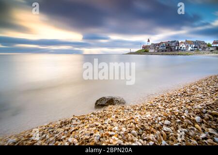 Coucher de soleil sur le phare d'urk sur la plage rocheuse au lac Ijsselmeer par l'ancienne île Urk Flevoland pays-Bas Banque D'Images