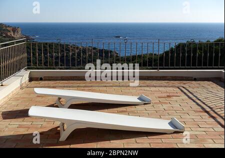 Deux chaises en plastique blanc sur une terrasse Banque D'Images