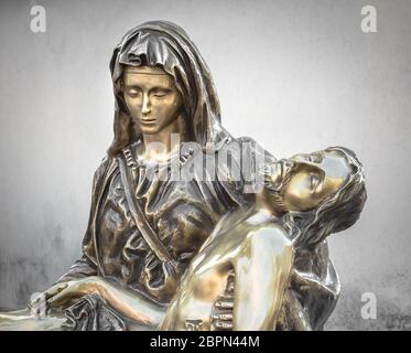 Statue en bronze de Jésus-Christ de la croix, d'être embrassé par la Vierge Marie. Arrière-plan sur un mur gris. Il peut être utilisé pour concept Banque D'Images