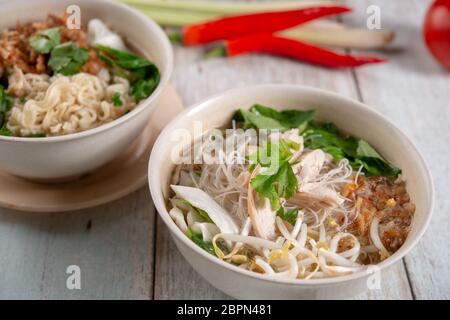 Soupe Asiatique au poulet nouilles dans un bol sur la table en bois. Banque D'Images
