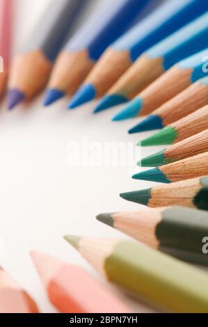 Close up crayons semi-circulaire dans des tons bleu et vert sur fond blanc. Banque D'Images