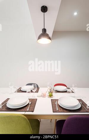 Table pour 4 personnes avec chaises colorées dans un appartement moderne et lumineux Banque D'Images