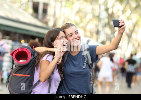 Backpacker friends avec selfies un téléphone intelligent dans la rue Banque D'Images