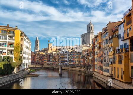 Bâtiments colorés sur la rivière Onyar, à Gérone, Espagne avec l'église de Saint Félix et de la cathédrale de Saint Mary s'élevant au-dessus de la ville Banque D'Images