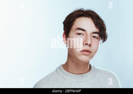 Studio portrait jeune homme de chandail gris sur fond blanc. Banque D'Images