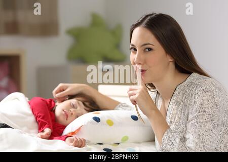 Pour demander le silence de la mère avec son enfant de dormir sur un lit dans la chambre à coucher dans une maison intérieur Banque D'Images