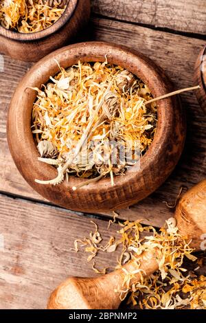 Herbes médicinales. Fleurs calendula séché dans le mortier Banque D'Images