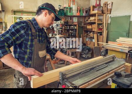 Chef de bloc de bois rabotés avec machine électrique Banque D'Images