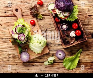 Les burgers de légumes servi sur une planche à découper sur la table rustique savoureux.Restauration rapide Banque D'Images