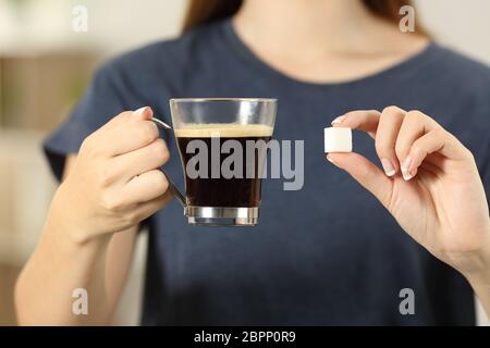 Vue avant close up of a woman hands holding Coffee cup et un morceau de sucre à la maison Banque D'Images