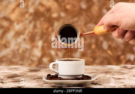 Verser le café noir de la glace dans une tasse. Banque D'Images