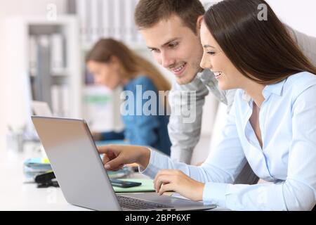 Deux heureux collègues sur la ligne de coworking avec un laptop at office Banque D'Images