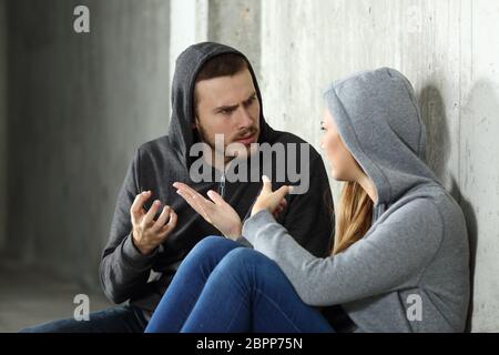 Disputes de couple assis sur le sol dans un endroit sombre Banque D'Images