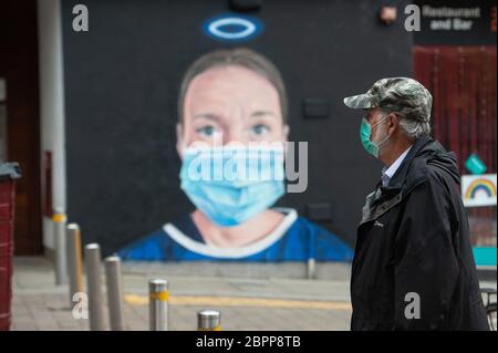 MANCHESTER, Royaume-Uni UN homme dans un masque facial marche devant une murale d'une infirmière avec un masque facial PPE, peint par l'artiste Akse dans le quartier nord de Manchester. Mardi 19 mai 2020. (Crédit : Pat Scaasi | ACTUALITÉS MI) crédit : ACTUALITÉS MI et sport /Actualités Alay Live Banque D'Images