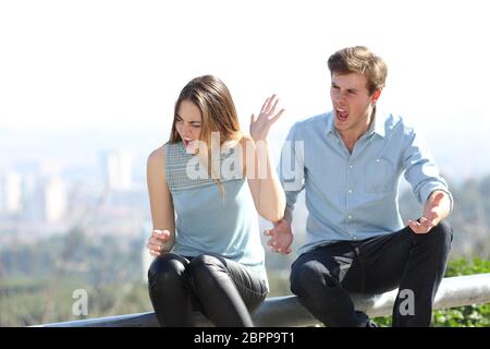 Angry couple arguing et crier les uns les autres dans une ville périphérie Banque D'Images